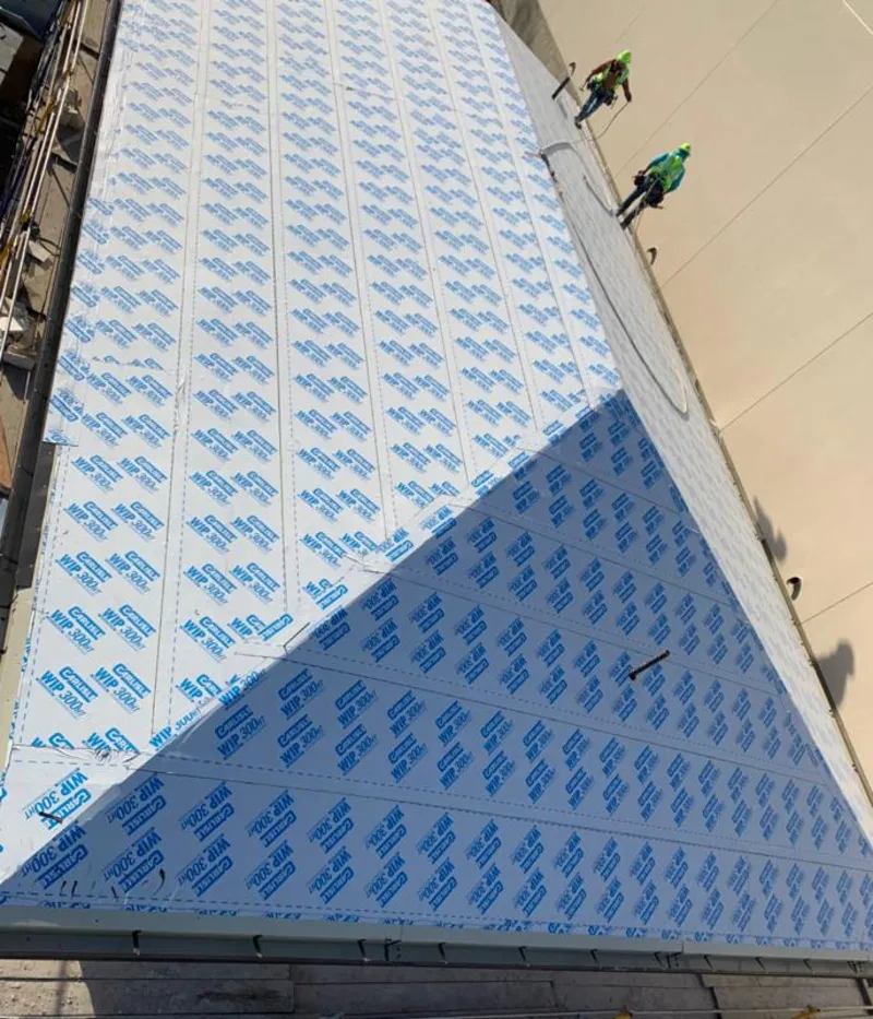 Professional roofers installing underlayment on a metal roof in Winchester